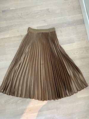 Hm plisserad midi kjol - Storlek XS, fint skick. Kamelfärgad, plisserad midikjol från h&m.
