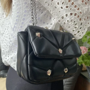 väska - jättefin svart väska med nitar och silverkedja som går att ha både kort och lång 👌🏼 otroligt snygg men har tyvärr kommit till användning för lite hos mig. Nyskick!! 