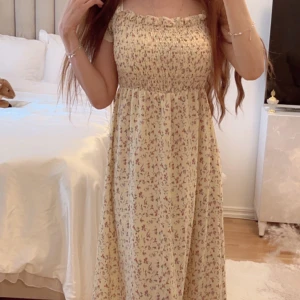 Cottagecore blommig klänning - Så fin gul/beige maxiklänning i cottagecore stil. Jätteskön och lätt samt smickrande. Är nästan 166 cm och den går 5 cm upp från ankeln på mig.