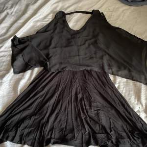 En helt svart klänning i storlek S, aldrig använd. Total längd 95cm