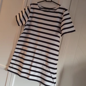 T-shirt - A-linjeformad t-shirt.  100% bomull.  Vit och blå-randig. 