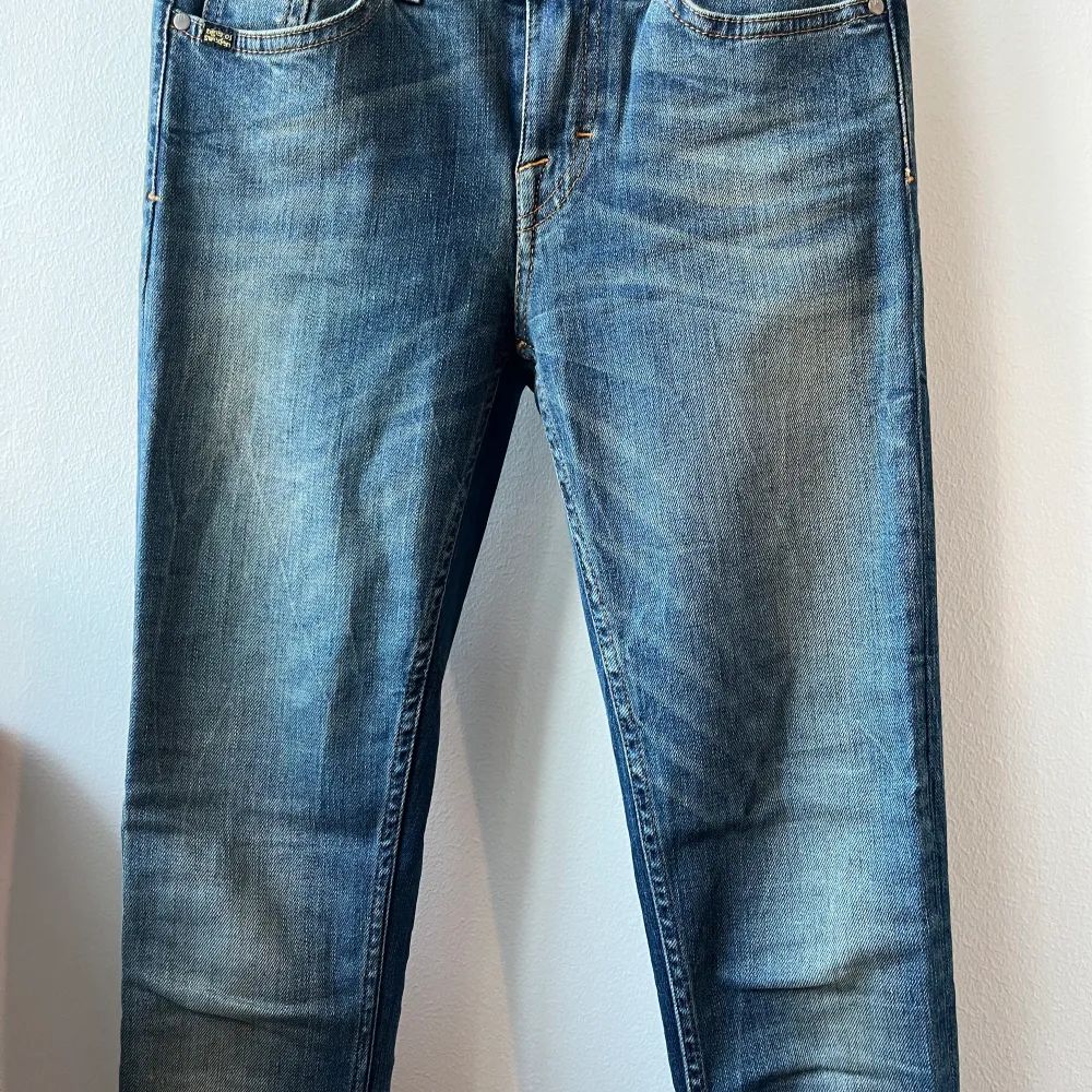 Ett par jeans från tiger of Sweden i storleken 26/34. Jeansen är använd vid få tillfällen dock har de en slitning ner till som visas på sista bilden.. Jeans & Byxor.