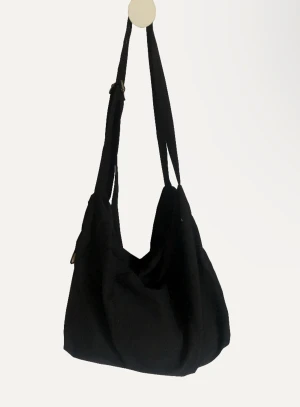 Tygväska - Säljer en svart axelremsväska. Den är i superfint skick, har ett fack inuti. Snörena går att lossa och spänna åt, pris kan diskuteras❤️