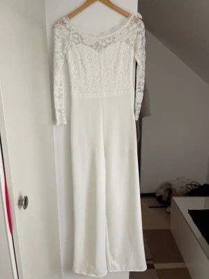 Jumpsuit - Vit jumpsuit från Nelly. Jumpsuiten är off shoulder med spets i storlek S. Endast använd en gång. 