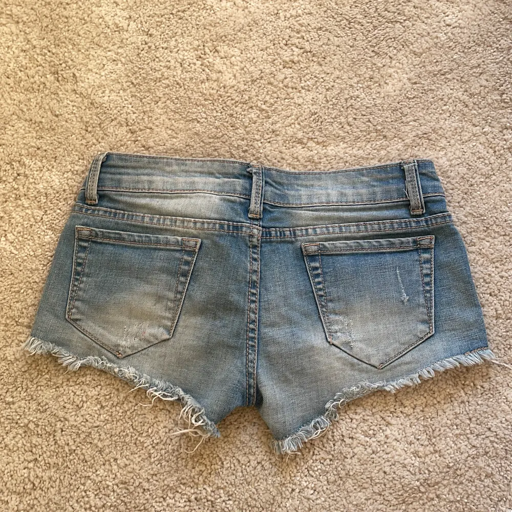 Jättefina low waist jeans shorts med en hjärt-detalj!❤️Strl S, men de är ganska små i storleken så skulle säga en 32-34 ungefär❤️. Shorts.