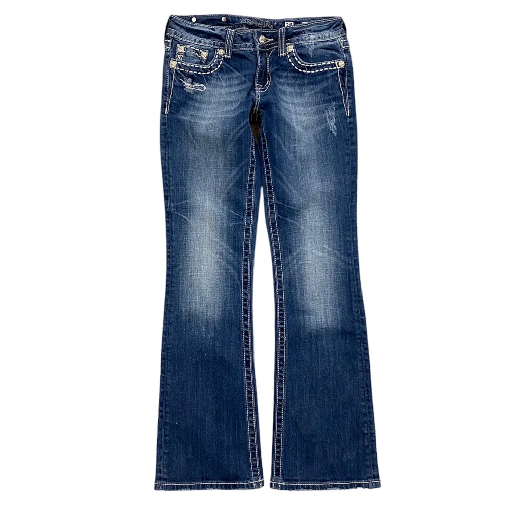 Ett par low waist bootcut Miss Me jeans i storlek 26. Jeansen är i fint skick med inga skador eller fläckar. Vid fler frågor eller mått tveka inte att kontakta oss!. Jeans & Byxor.