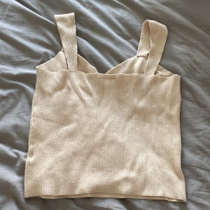 Ett ribbat linne - Jag säljer mitt superfina ribbade linne som är jätteskön! Den är i färgen gräddvit/beige och är från Kappah! Stl M!😊 