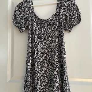 Klänning - Sommarklänning från Primark som är svart med vita blommor. Säljer för att den är för kort.