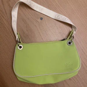 Grön väska  - Grön väska från Lacoste. Inga defekter utan är i toppskick samt kvalitet 🥰 limited edition
