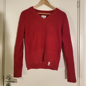 Ribbad röd tjocktröja - Superfin och bekväm ribbad tjocktröja från märket boomerang. Halsen är en aning v-ringad. Tröjan är croppad i modellen.