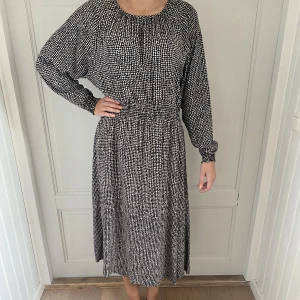 Klänning i svartvitt mönster - Fin klänning i snyggt mönster i svartvitt. Resår i midjan. Storlek bortklippt men är en 40.
