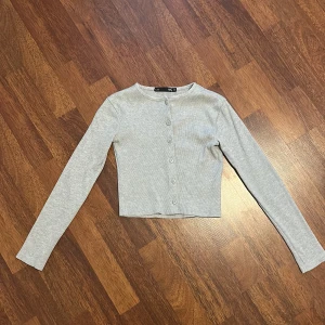 Kofta  - Grå långärmad ribbad kofta i strl xs från lager 157. 