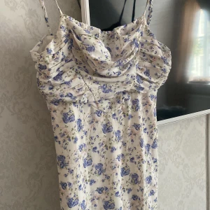 Blommig klänning  - Fin blommig klänning med slits  Köpte på plick oanvänd och är fortfarande som ny  Strl Xs sitter tajt på kroppen och formar fint ! 
