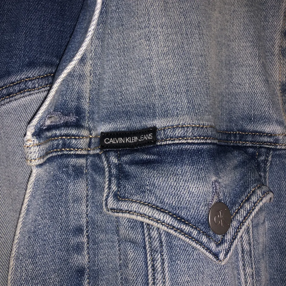 Jeans jacka från Calvin Klein. Figursydd med fickor längs sömmarna. Jackor.