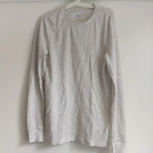 Tunn vit långärmad tröja - Långärmad tröja som är tunn nog att ha i tisha under. I bomull med våffel/randig textur. Köparen står för frakt