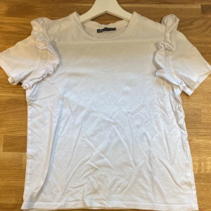 Vit volangtshirt - En jättefin volangtshirt från Zara. 