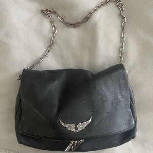 Zadig Voltaire väska - Säljer min Zadig Voltaire Rocky väska! Den är köpt för ca 2 år sedan. Väskan har tecken på användning då kedjan tappat lite färg, men det är något jag själv aldrig tänker på! Det tillkommer även ett till band till väskan. Skriv för fler bilder. 