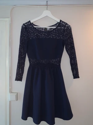 Klänning - Fin mörkblå klänning med spetspartier. Hela ryggpartiet är spets. 