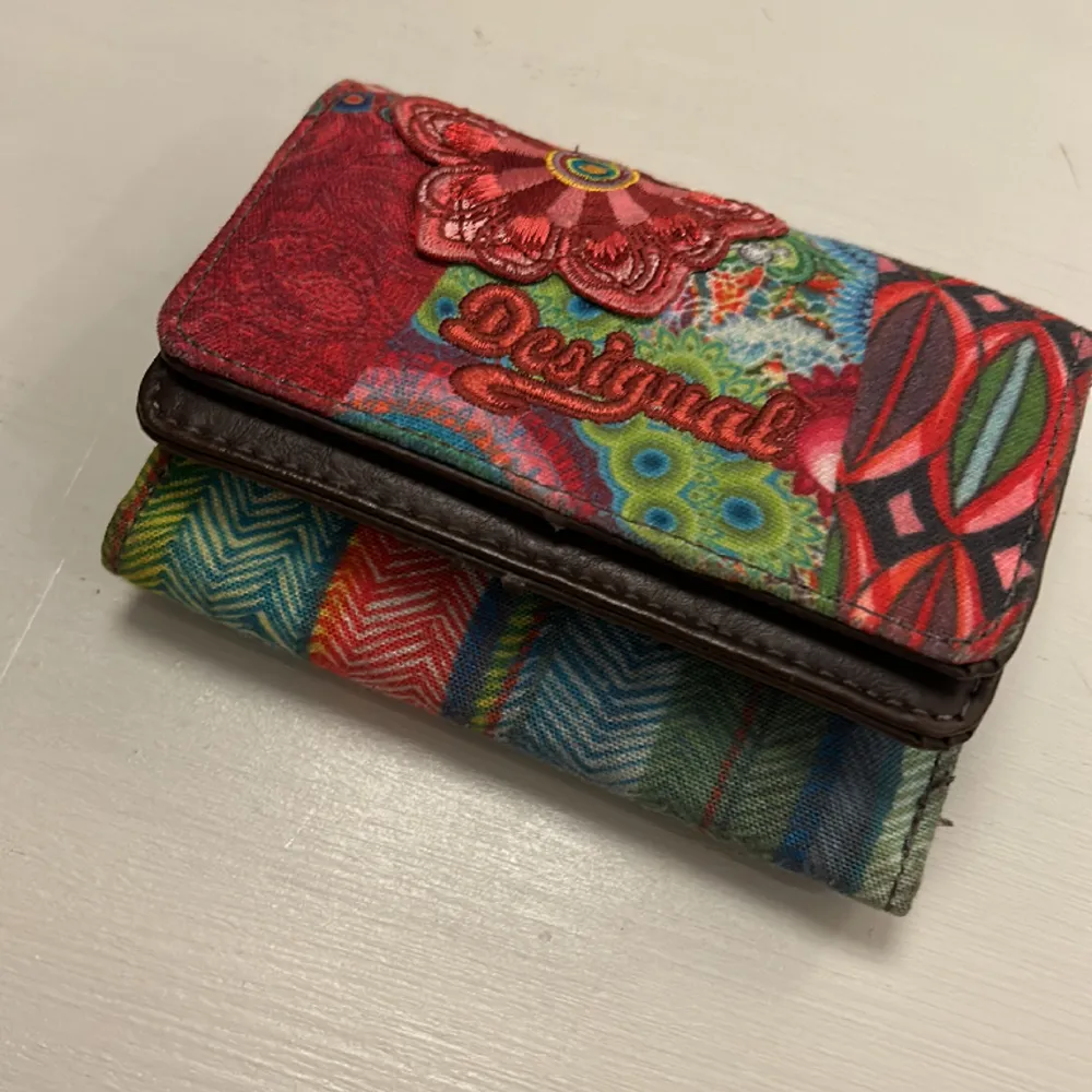 Säljer en Desiqual plånbok. Brun och röd med 6 fack för kort och mynt. . Övrigt.