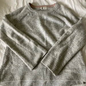 Stickad tröja  - Ljusgrå stickad tröja från H&M. Ganska nopprig men fin