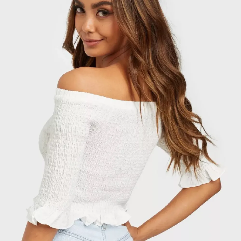 Glamorous Smock top Köpt för 299 kr på Nelly, säljes för 120 kr Använd 1 gång. Storlek 36. Off shoulder topp från Glamorous Smockad med volang nedtill samt vid ärmslut Resår upptill Modellen är 174 cm lång och bär storlek EU 36.. Puserot.