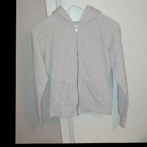 Ljusgrå Hoodie XS Bikbok - Mycket fin Hoodie med ett svagt rutaktigt lite glittrande mönster som var lite svårt att få med på bild. Väldigt bra skick förutom att snöret runt luvan saknas. Men enkelt att sätta dit ett nytt. Strl XS från Bikbok. 80%bomull 20%polyester. 