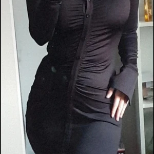 Svart klänning - Svart kort klänning. Långärmad med knappar. Från hm, den är använd men är i fint skick.