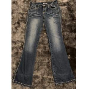 Snygga lågmidjade jeans i bootcut/flare modell med fina beiga detaljer!! Kan absolut skicka fler bilder om behövs!🫶 Innberbenslängden: 80 cm Midjemåttet: 38 cm (tvärsöver)