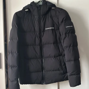 Calvin Klein jacka - Säljer nu min fina Calvin Klein jacka då jag köpt en ny, den har en liten defekt på vänster armen men knappt något som syns.  Annars väldigt fin. Storlek small men passar även medium