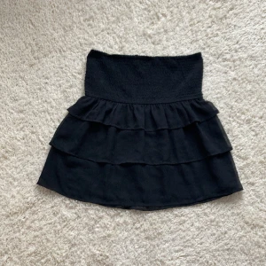 Svart volangkjol från Gina tricot - Säljer denna otroligt fina volangkjol från ginatricot, då den knappt kommit till andvändning. Den är i storlek S och har bara andvänds ett flertal gånger.