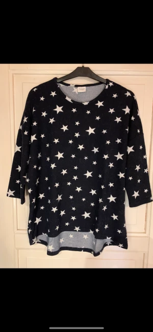 Jacqueline De Young Topp. St: ~ S / M / L.  - Jätte fin topp från Jacqueline De Young. Färg: Mörk marinblå med ett hav av vita stjärnor. Mått: från ärmhåla till ärmhåla: 2 x 57 cm. Från ärmhåla till nederkant: 40 cm. Hel längd bakstycke: 68 cm. Ärm trekvarts. Skick: Mycket bra. Post Nord 60 kr. 