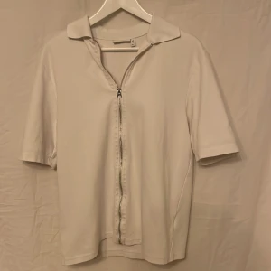 Weekday T Shirt - Zip T Shirt från weekday i nyskick. Köpt för länge sen men inte använt. Köptes för runt 500, mitt pris 200. Storlek XS men passar S också