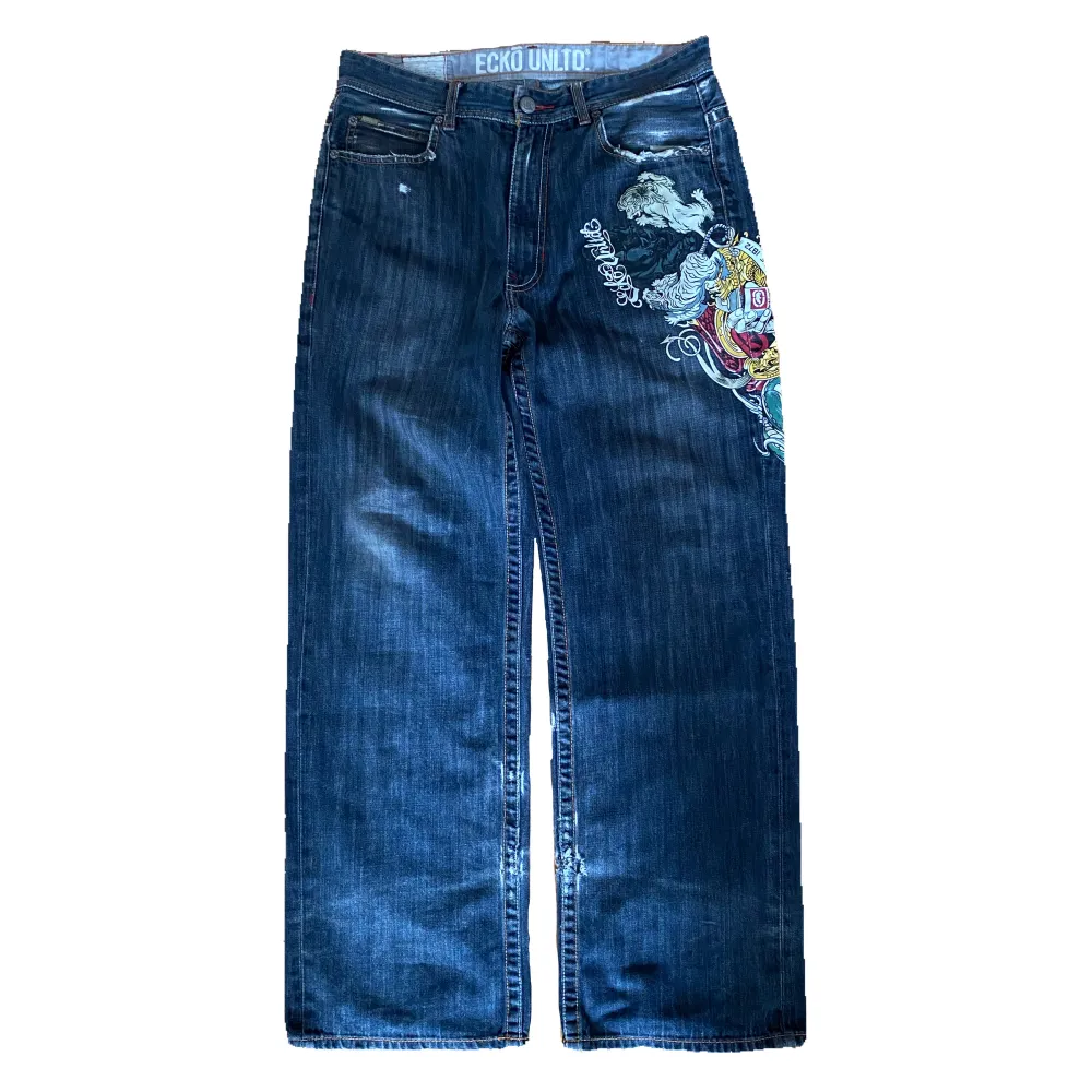 Vintage baggy Eckō Unltd jeans från 2000-talet med coolt tryck och detaljer. Jeansen är lite slitna och har ett hål vid slutet av benet på baksidan men fotfarande i helt okej skick. Känn dig fri att fråga om du undrar något!. Jeans & Byxor.