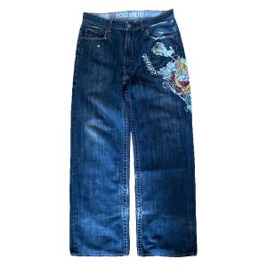 Vintage baggy Eckō Unltd jeans från 2000-talet med coolt tryck och detaljer. Jeansen är lite slitna och har ett hål vid slutet av benet på baksidan men fotfarande i helt okej skick. Känn dig fri att fråga om du undrar något!