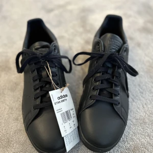 Stan Smith Adidas oanvända - Helt nya Stam Smith svarta. Var för liten storlek och lyckades inte skicka tillbaka i tid.:-)  Finns på Östermalm i Stockholm. 