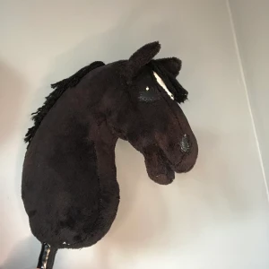 Käpphäst - Käpphäst i ganska fint skick. Lite slitna ställen plus att örat har ett litet hål i sig vid sömmen. Just nu är hålet fixat med en knappnål. Köpt för 750 men p.g.a att den är lite sliten så säljer jag den för 600. Tränsen kostar 15kr extra.