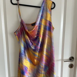 Multifärgad klänning - Säljer denna superfina multifärgade klänning från ASOS då den inte kommer till användning. Modellen är ganska kort men går att göra om till en söt topp. Storleken är i uk 14 motsvarar 42/44🌈 Nytt skick! Skriv för bättre bilder🥰