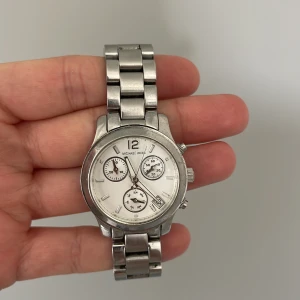 Michel kors klocka - Äkta Michel kors klocka i hyfsat skick (ni ser lite rost(?) på bandet, men inget som syns överdrivet). Nypris 2800kr, tvättar klockan innan sälj så den blir ren och fin igen! Även batteriet måste bytas då jag ej använt den på något år.