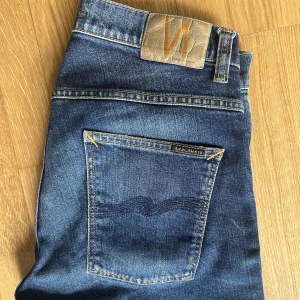 Nudie Jeans  - Nudie jeans - Grim Tim W32 L30  Sparsamt använda, men de har tyvärr fått en mindre färgfläck på insida lår   