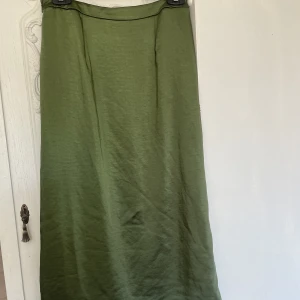 Grön satinkjol  - En fin satin kjol som passar perfekt nu till sommaren. Endast använd fåtal gånger. 
