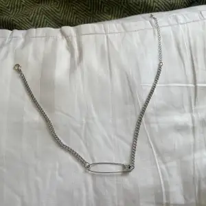 silvrigt halsband med en säkerhetsnål, nästan helt oanvänd. ungefär 48 cm