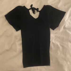 Svart topp - Jättesöt svart topp med liten uringning och knytning i nacken från Only💘Använd fåtal gånger, säljer pga kommer ej till användning🥰