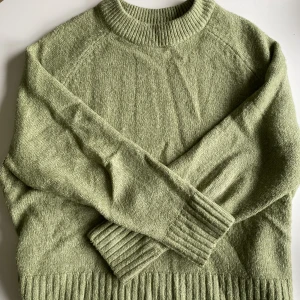 Stickad tröja - Olivgrön stickad tröja från pull and bear. Mysig och varm! Tröjan är väl omhändertagen och i mycket bra skick!