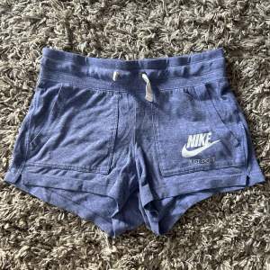 Lila Nike shorts med fickor framtill och snöre i midjan. 