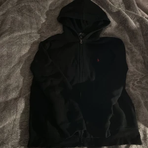 Ralph lauren zip hoodie  - En svart Ralph lauren zip Hoodie Anledning: använder slutat använda den pågrund av den är för liten.