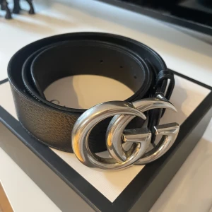 Svart Gucci bälte - Svart Gucci bälte. Köpt via Guccis hemsida, orgnailkvitto finns. Storlek 90. Knappt använt, därav nyskick. Ingår orginalpåse och låda. Aktuellt pris på hemsida $520