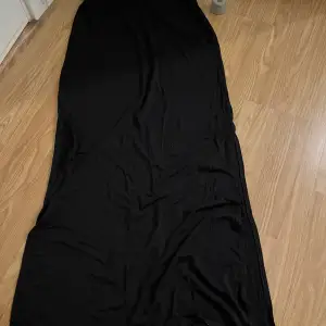 Lågmidjad svart kjol me två styckna slits