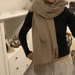 Stor beige halsduk  - Stor, beige, mysig halsduk perfekt nu tilm hösten och vintern. Måtten på den är 190cm x 80cm. Är i väldigt bra skick och väl omhändertagen. 
