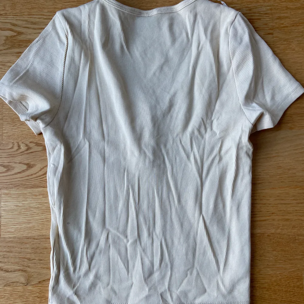 Ribbad t-shirt med urignning och knappar. Från Gina tricot. Använd fåtal gånger och den är för liten för mig nu. Storlek S. Säljer för 70 kr+ frakt. Skriv om ni har frågor.. T-shirts.
