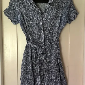 Klänning - Skön sval bommulsklänning. Knälång, småblommig i blått och vitt.”Jumpherfabriken” är ett kvalitetsmärke. Klänningen kostade 1750kr som ny.